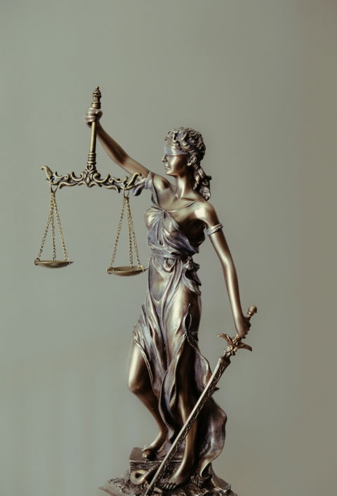 woman in gold dress holding sword figurine
